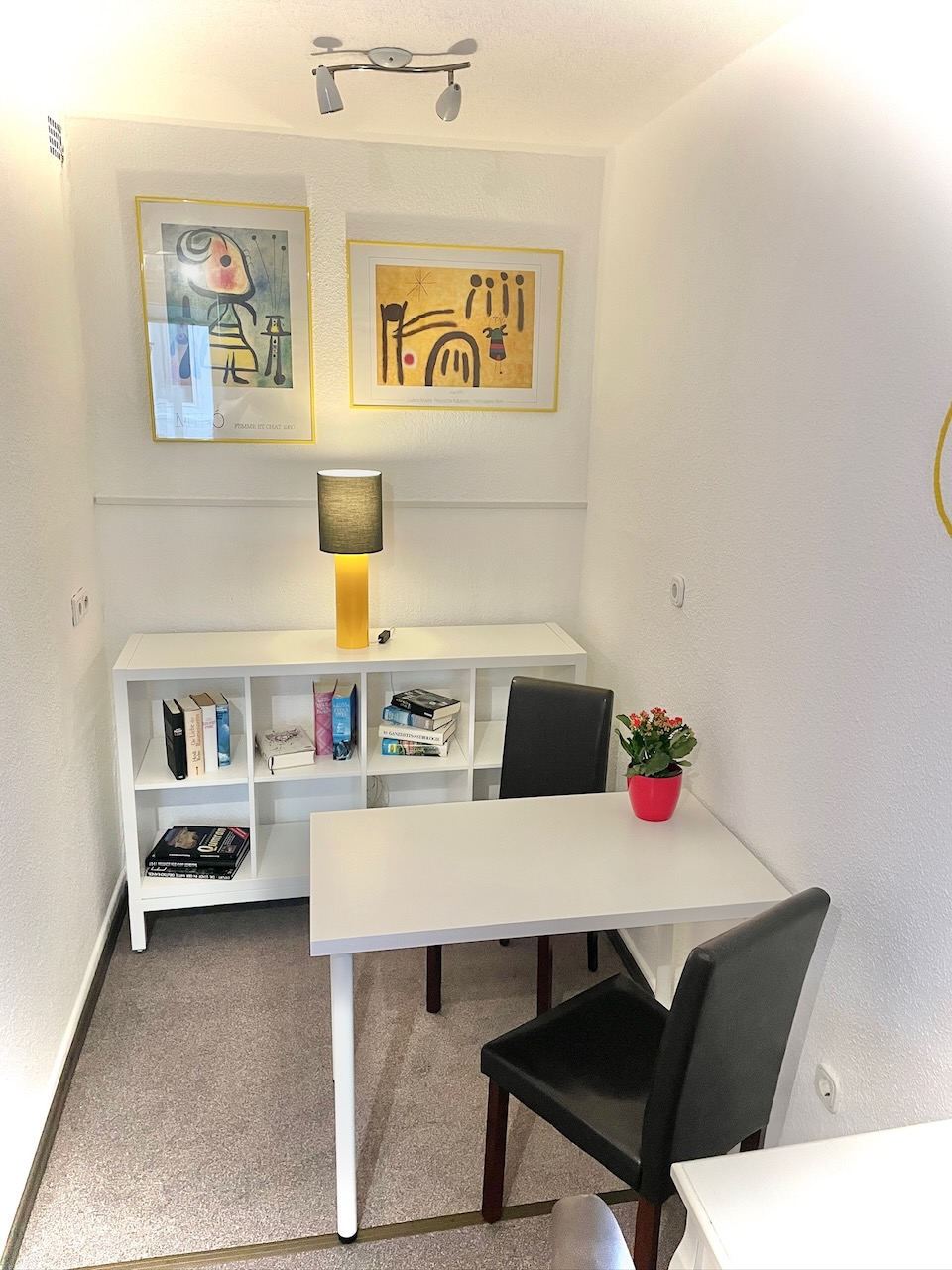 Sitzecke mit Tisch, zwei Stühlen und Bücherregal