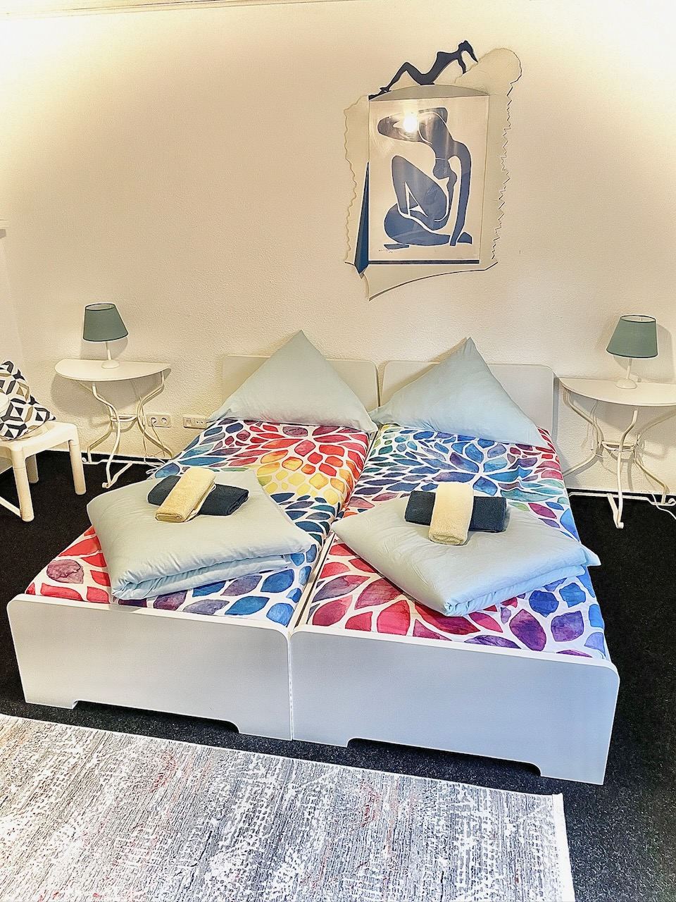 Doppelzimmer mit bunter Bettwäsche und Matisse-Druck über dem Bett