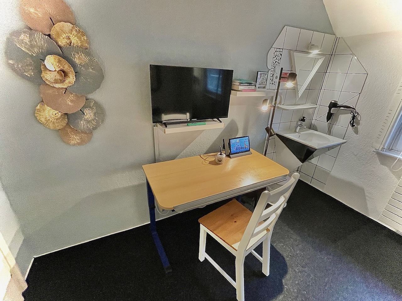 Einzelzimmer unter dem Dach mit Schreibtisch, TV und Waschbecken